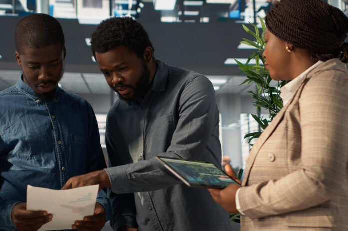 Smiling business people working and using tablet in outdoor cafe